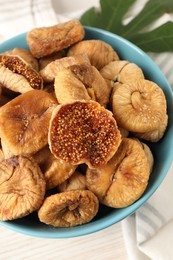 Photo of Bowl with tasty dried figs on white wooden table, above view
