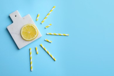 Photo of Sun made with lemon slice and cocktail straws on light blue background, flat lay. Space for text