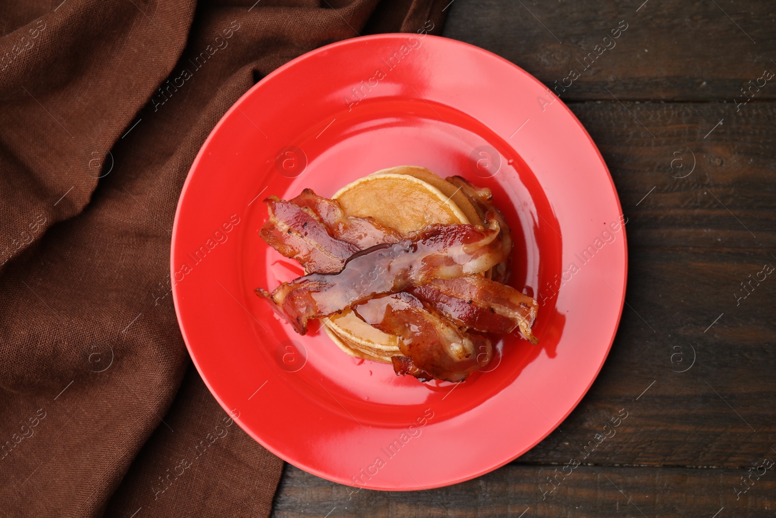 Photo of Delicious pancakes with bacon and honey on wooden table, top view