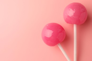 Tasty lollipops on pink background, flat lay. Space for text