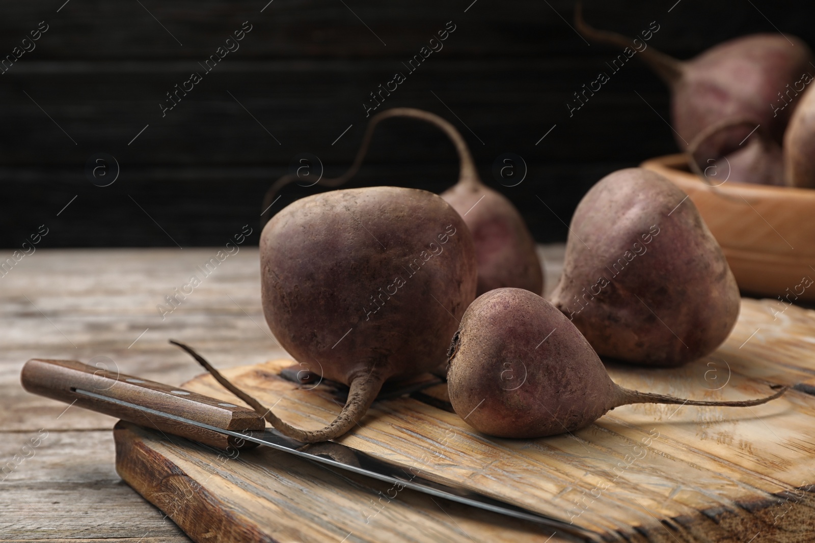 Photo of Wooden board with ripe beets on table