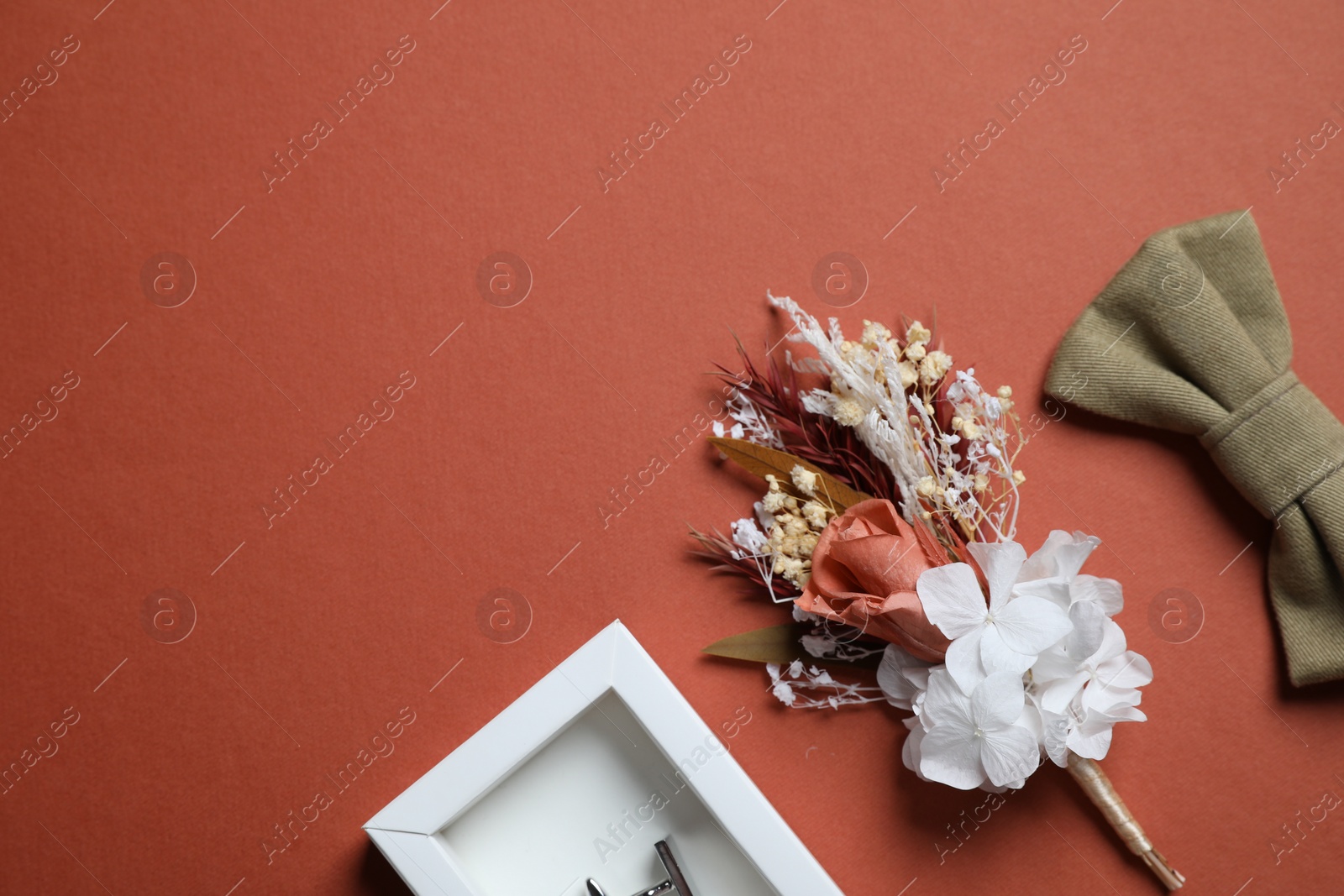 Photo of Wedding stuff. Stylish boutonniere, bow tie and cufflink on brown background, space for text