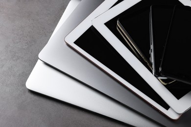 Photo of Many different modern gadgets on grey table, closeup