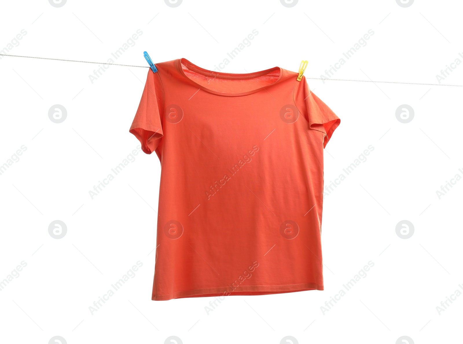 Photo of One orange t-shirt drying on washing line isolated on white