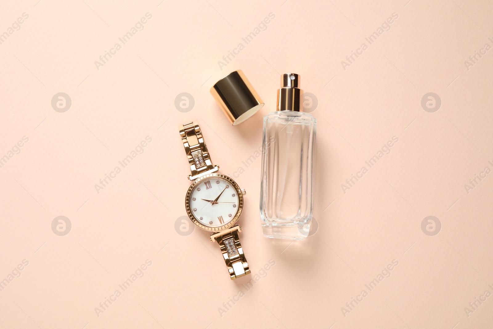 Photo of Luxury wrist watch and perfume on beige background, flat lay