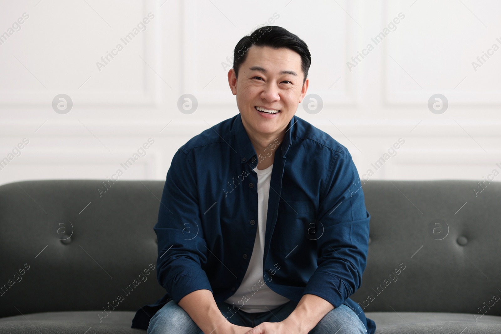 Photo of Portrait of smiling businessman with smartphone indoors
