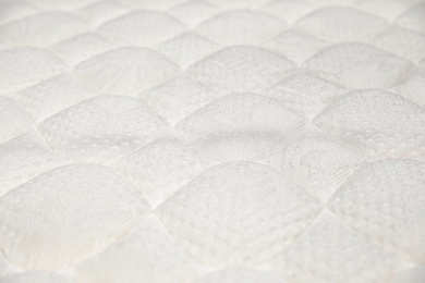Photo of Modern white comfortable orthopedic mattress as background, closeup