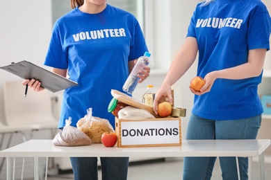 Volunteers with donation box and clipboard indoors