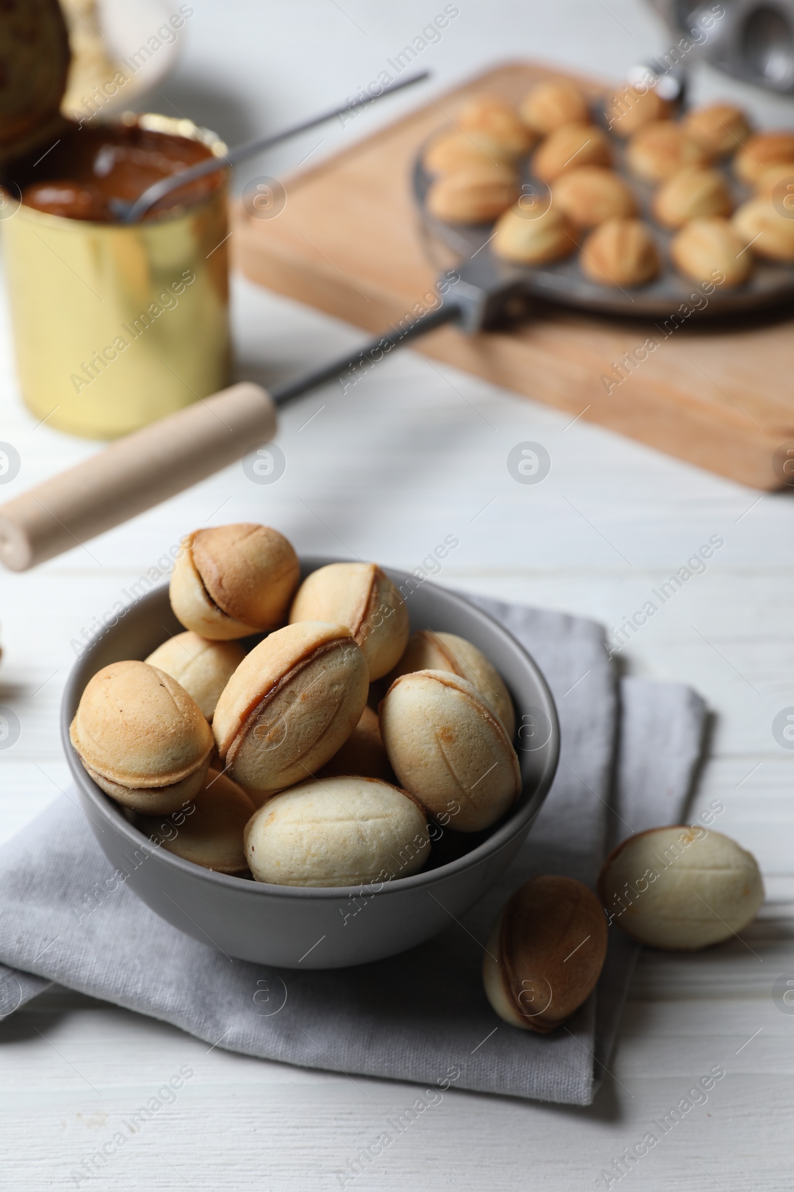 Photo of Delicious walnut shaped cookies with condensed milk on white wooden table