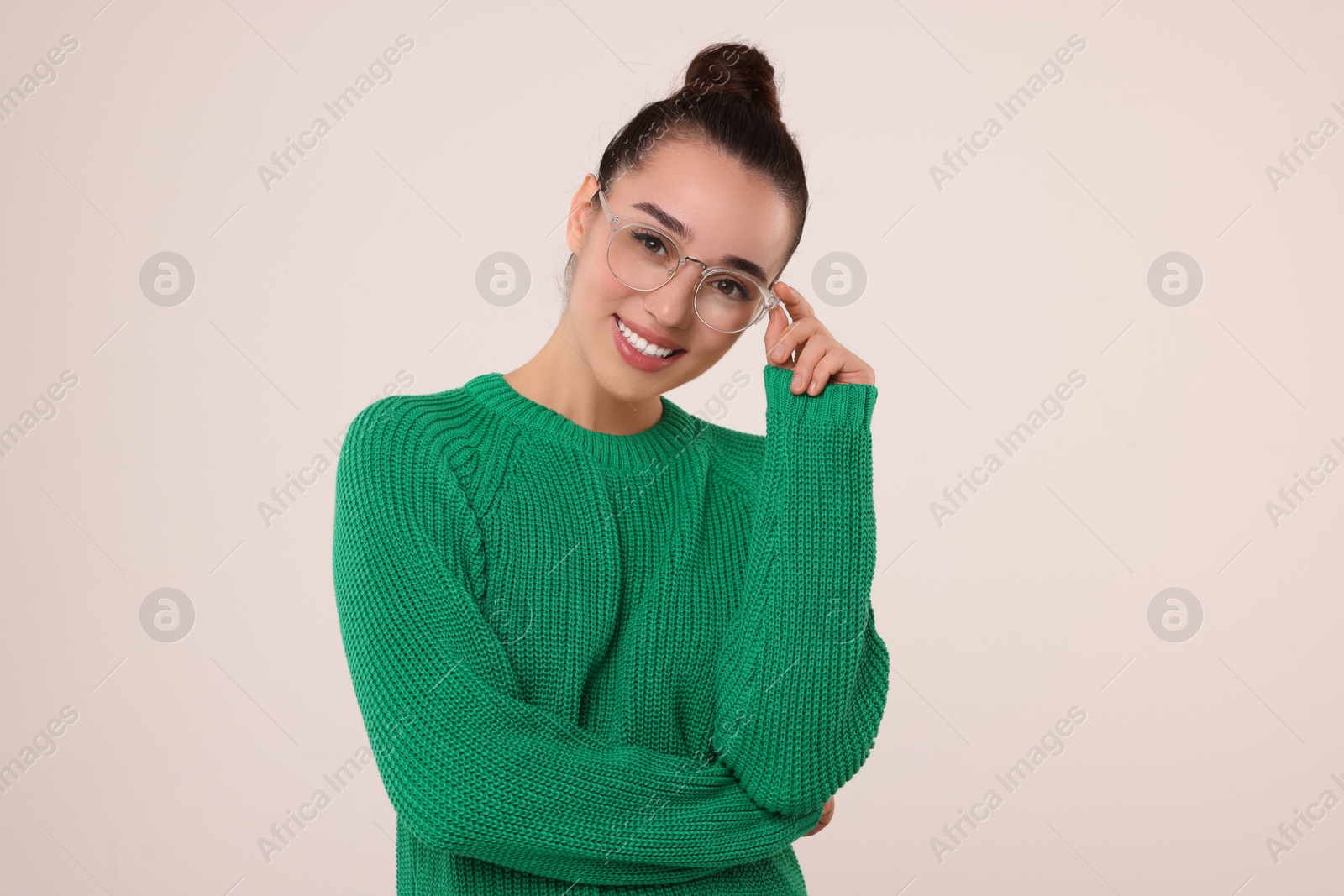 Photo of Beautiful young woman in stylish warm sweater on light grey background