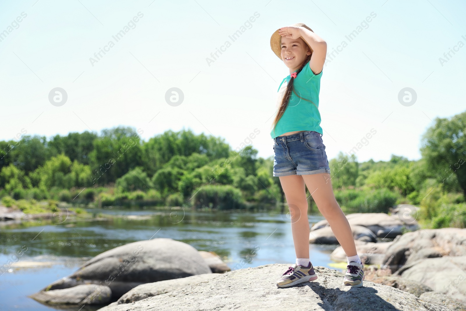 Photo of Little girl at riverside. Summer camp
