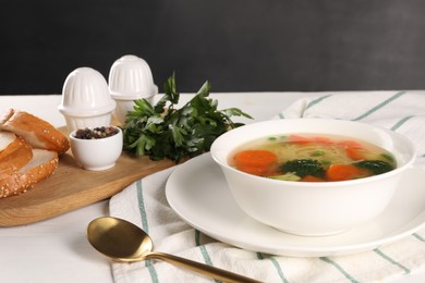 Photo of Delicious vegetable soup with noodles served on white wooden table