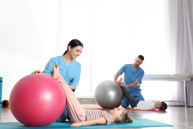 Photo of Orthopedists working with little children in hospital gym