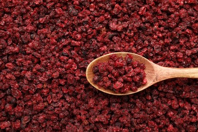 Wooden spoon on dried red currants, top view. Space for text