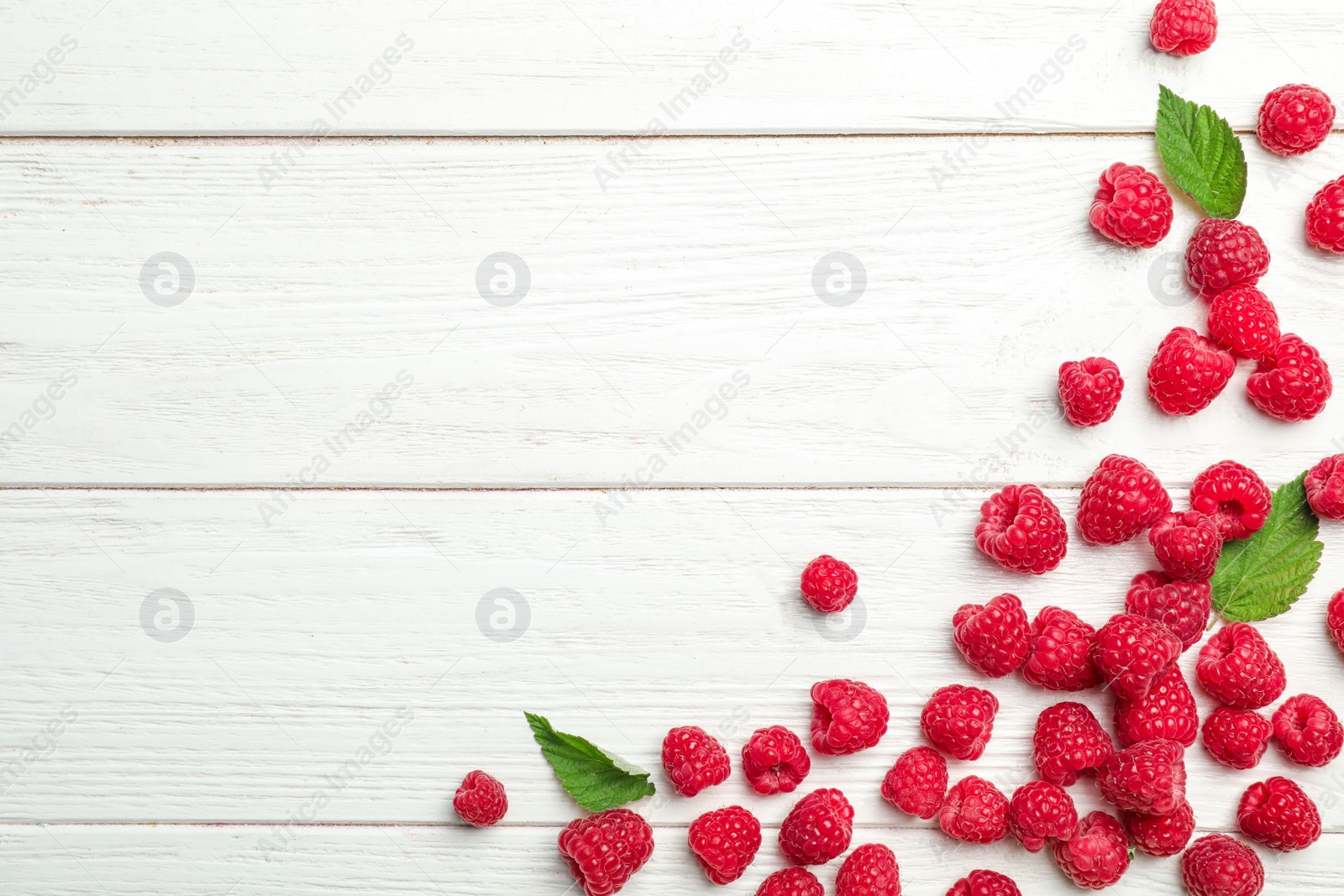 Photo of Ripe aromatic raspberries on wooden table, top view