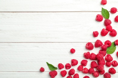 Photo of Ripe aromatic raspberries on wooden table, top view