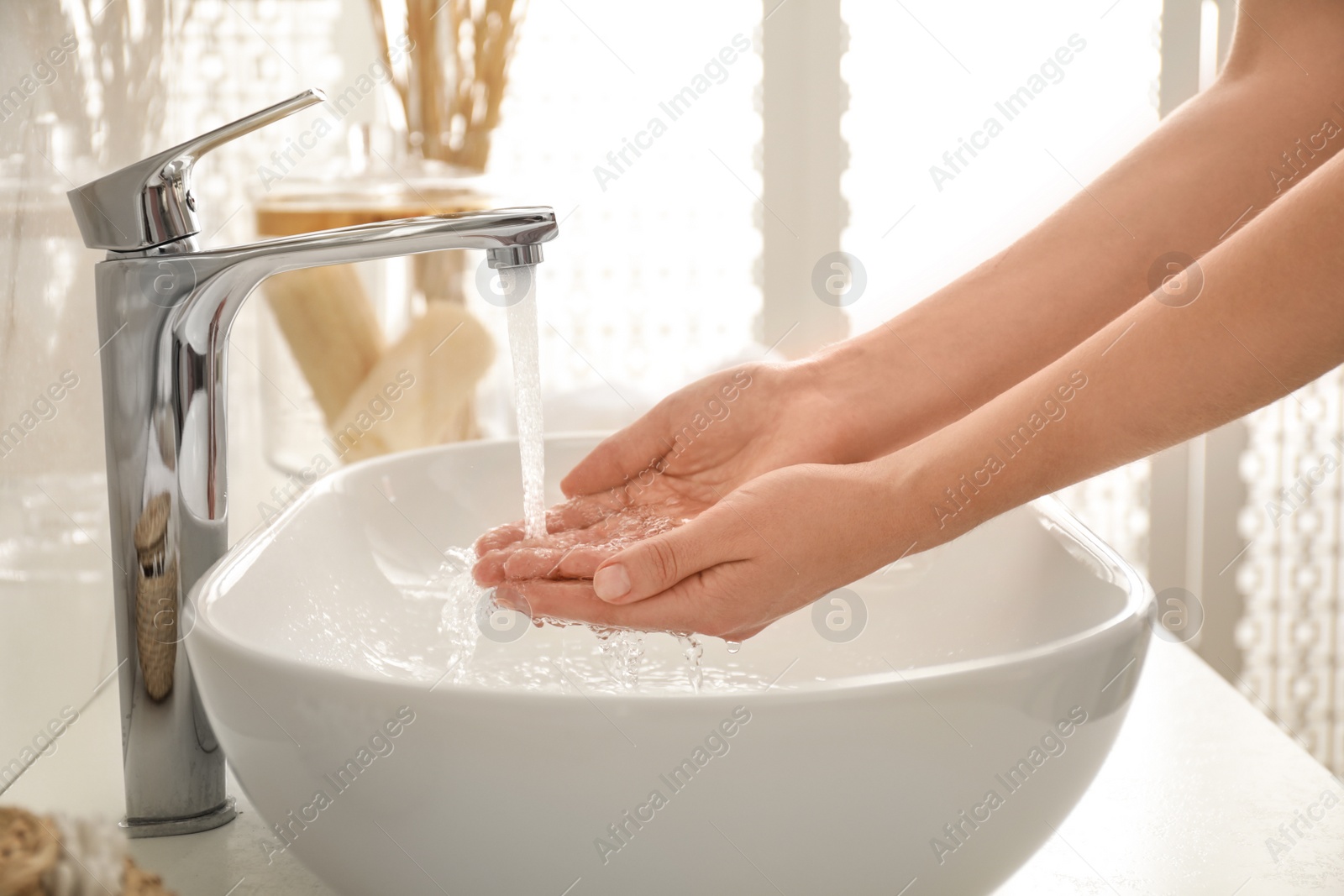 Photo of Woman washing hands indoors, closeup. Bathroom interior