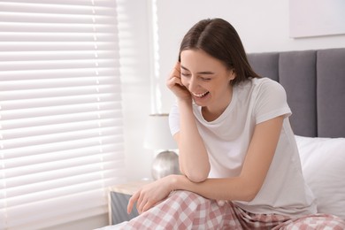 Photo of Portrait of beautiful woman laughing in bedroom. Space for text