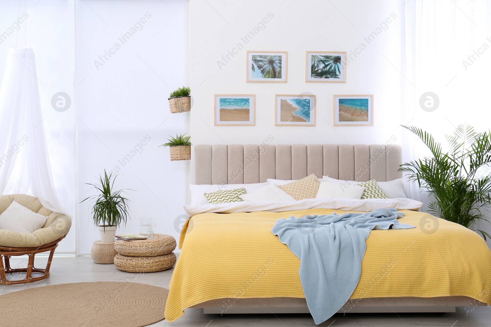 Photo of Stylish room interior with large comfortable bed and beautiful paintings