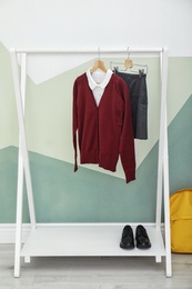 Photo of School uniform for girl on rack near color wall