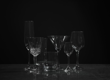 Photo of Set of bar glassware on table against dark background