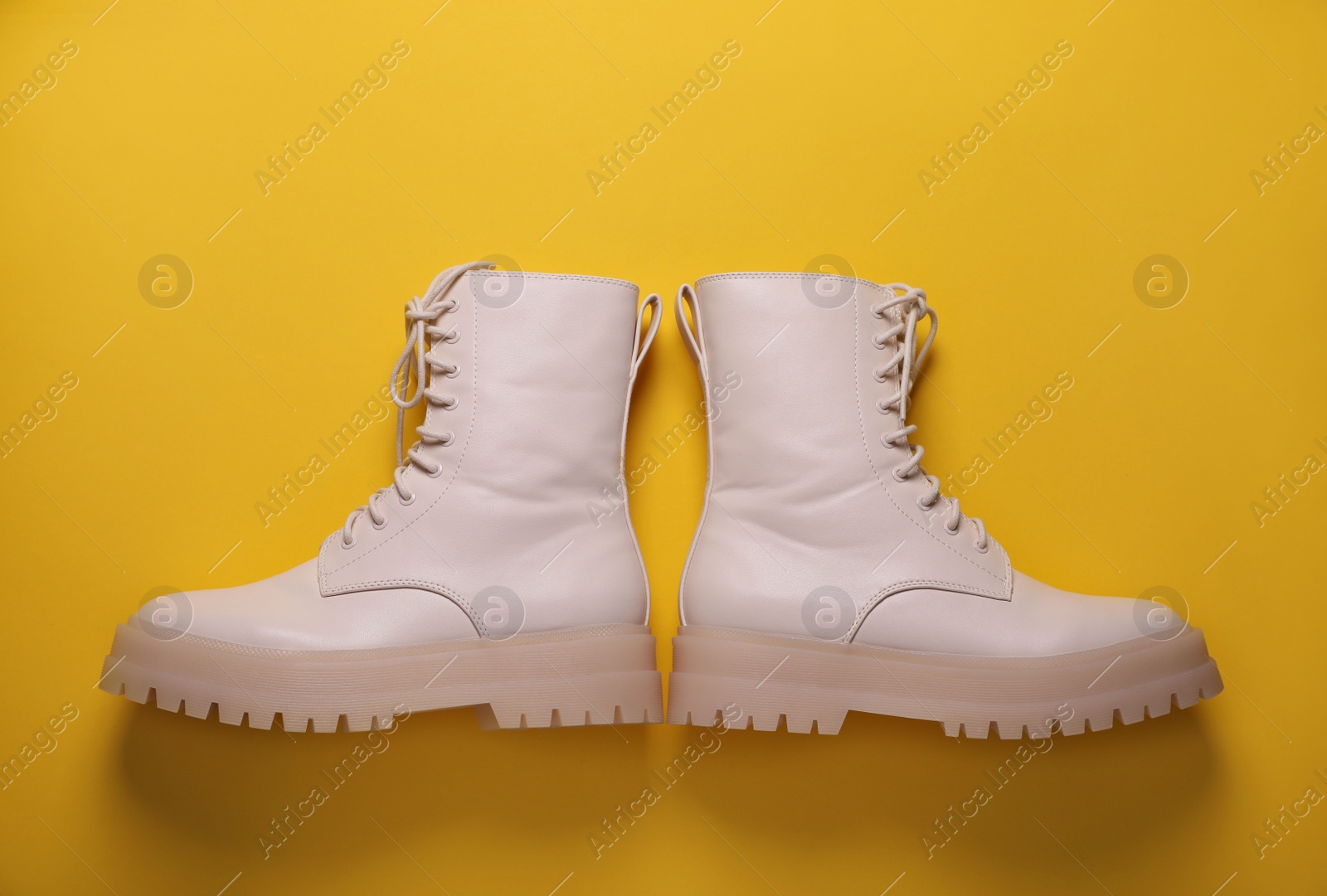 Photo of Pair of stylish shoes on yellow background, flat lay