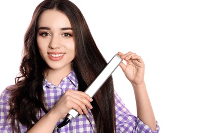 Happy woman using hair iron on white background