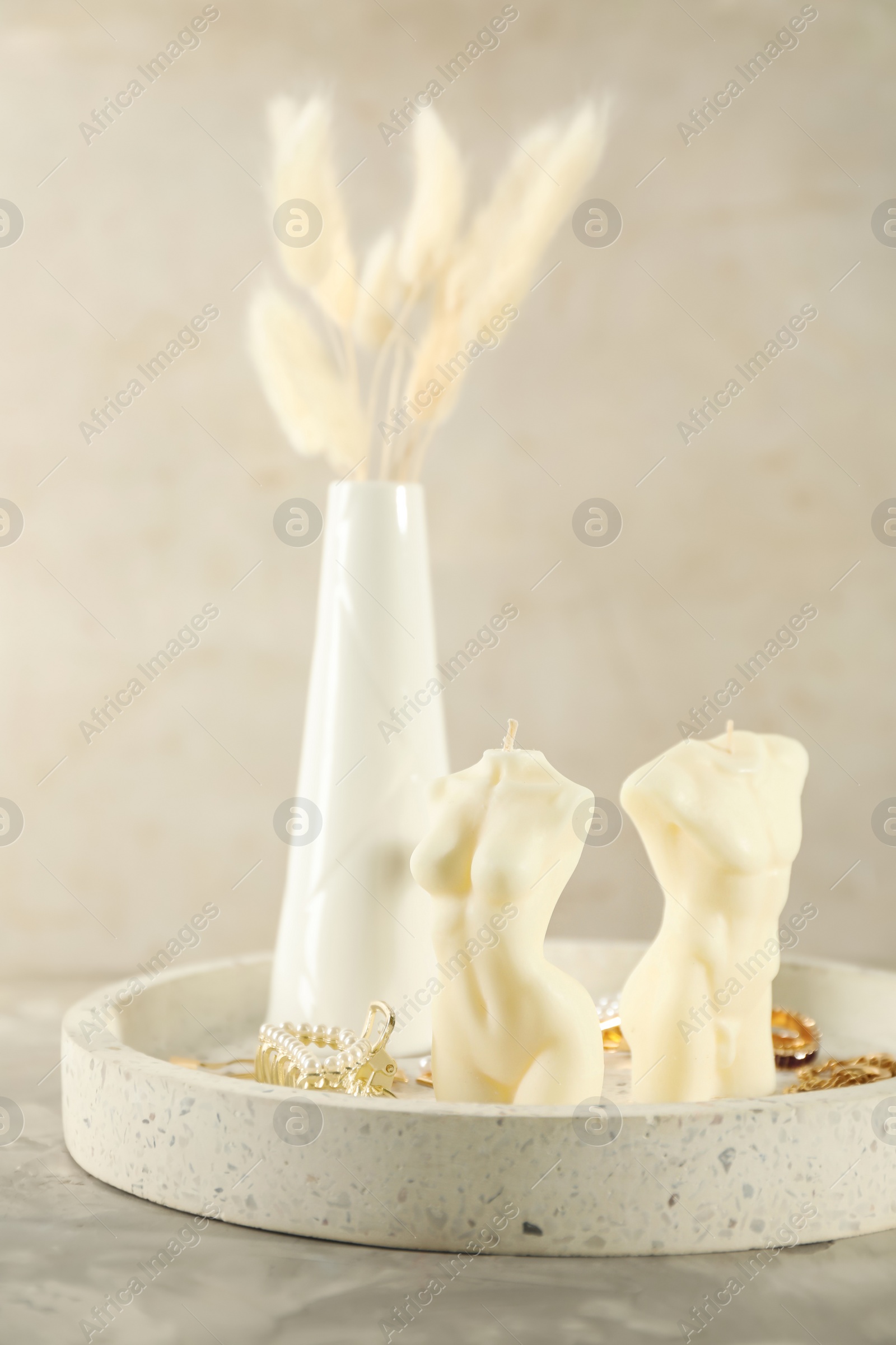 Photo of Beautiful male and female body shaped candles with accessories on grey table