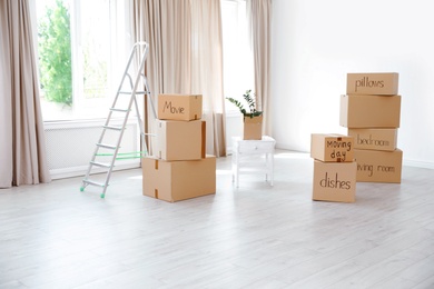 Ladder and cardboard boxes in empty room. Moving day