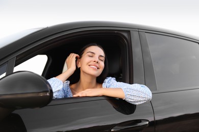 Photo of Enjoying trip. Portraitbeautiful happy woman in car, view from outside
