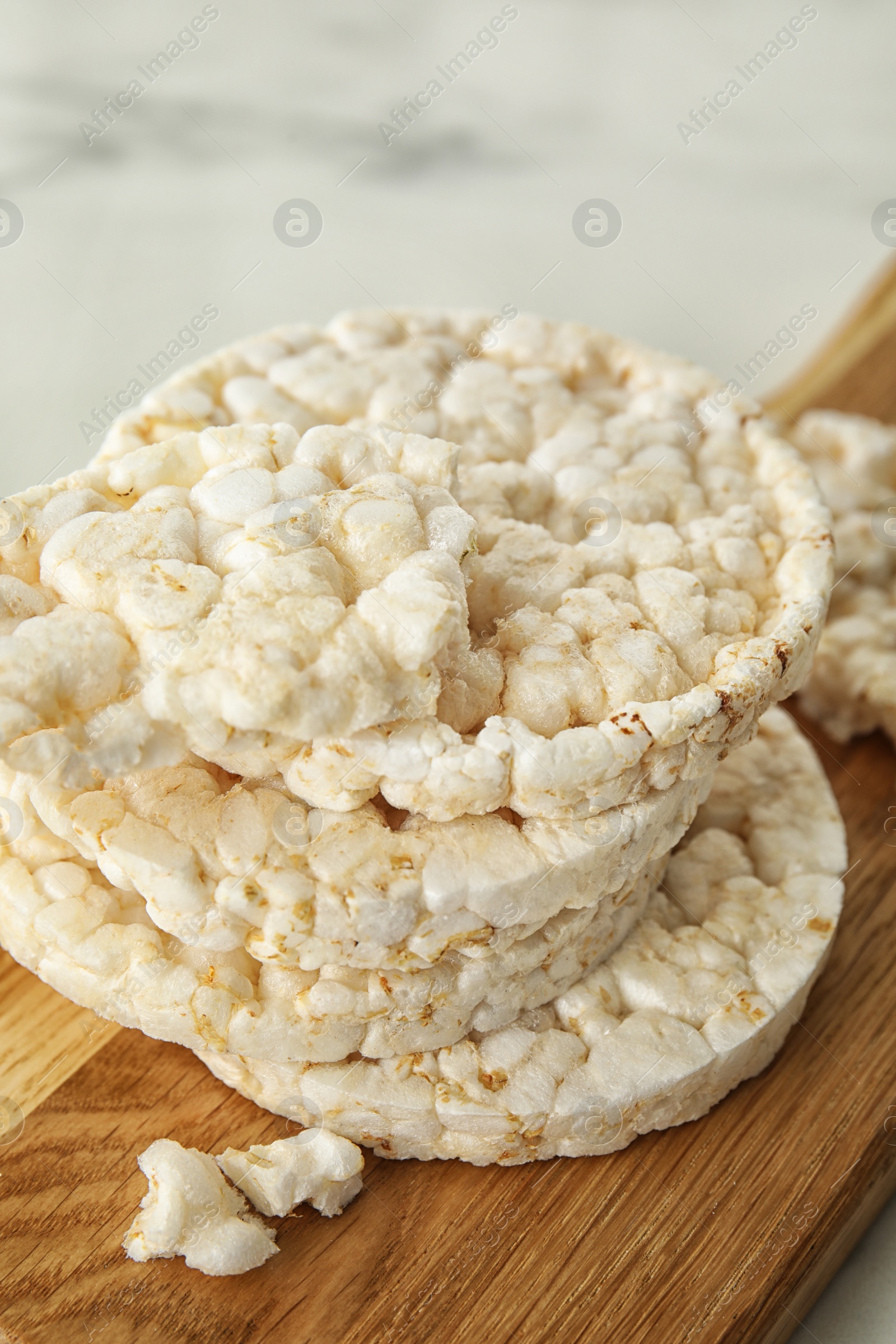 Photo of Crunchy rice cakes on wooden board, closeup