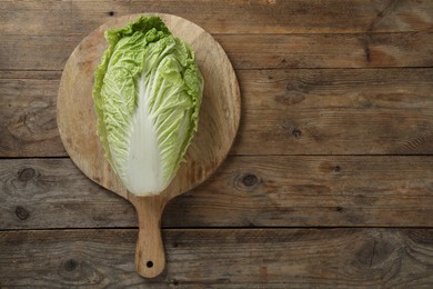 Cutting board with fresh ripe Chinese cabbage on wooden table, top view. Space for text