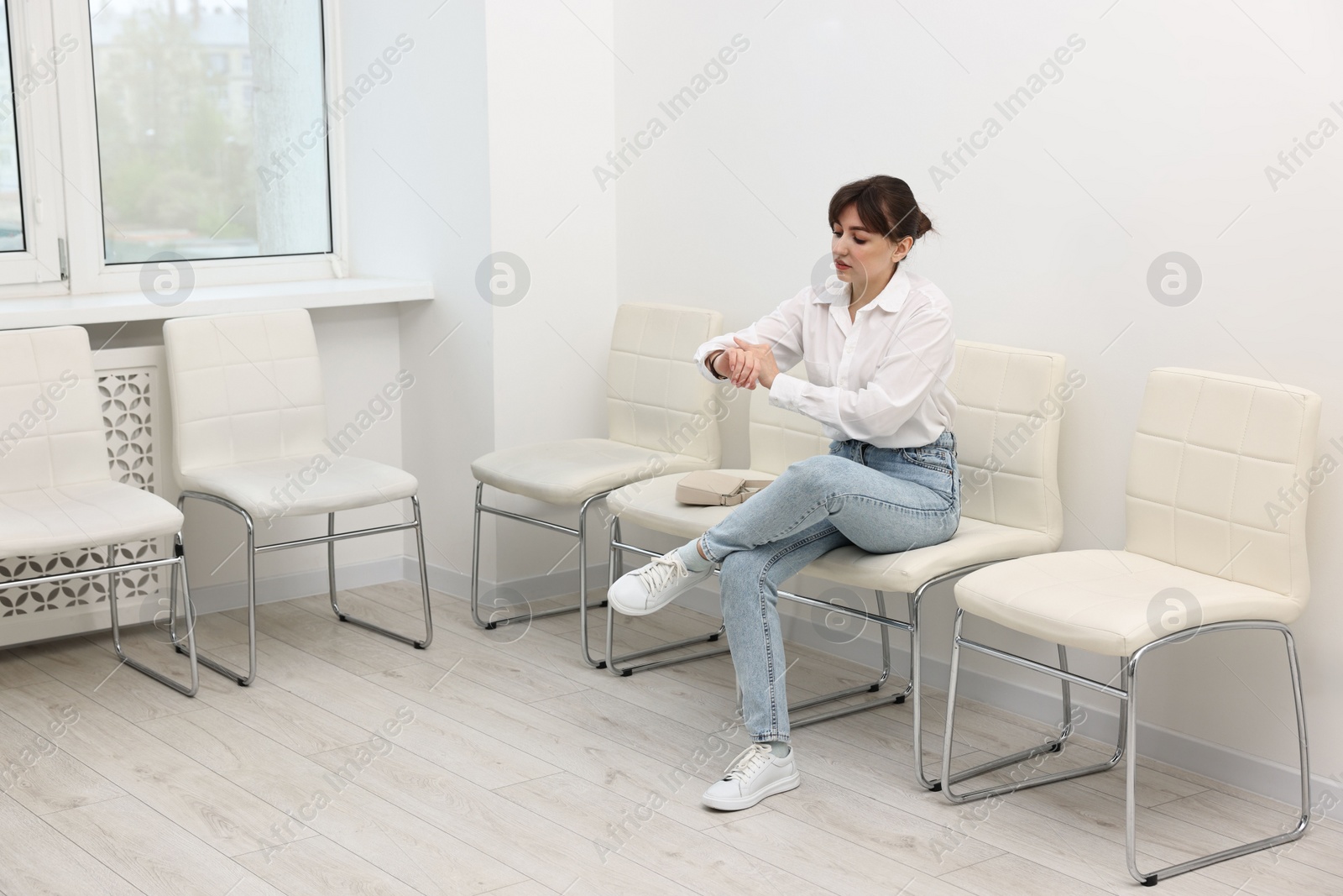 Photo of Woman sitting on chair and waiting for job interview indoors