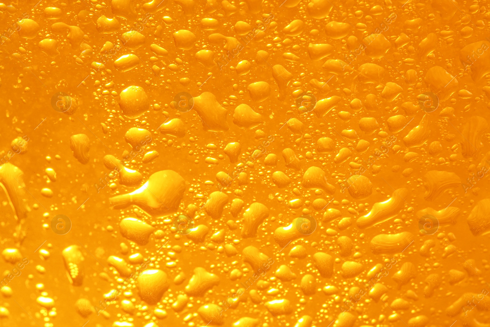 Photo of Glass of tasty cold beer with condensation drops as background, closeup