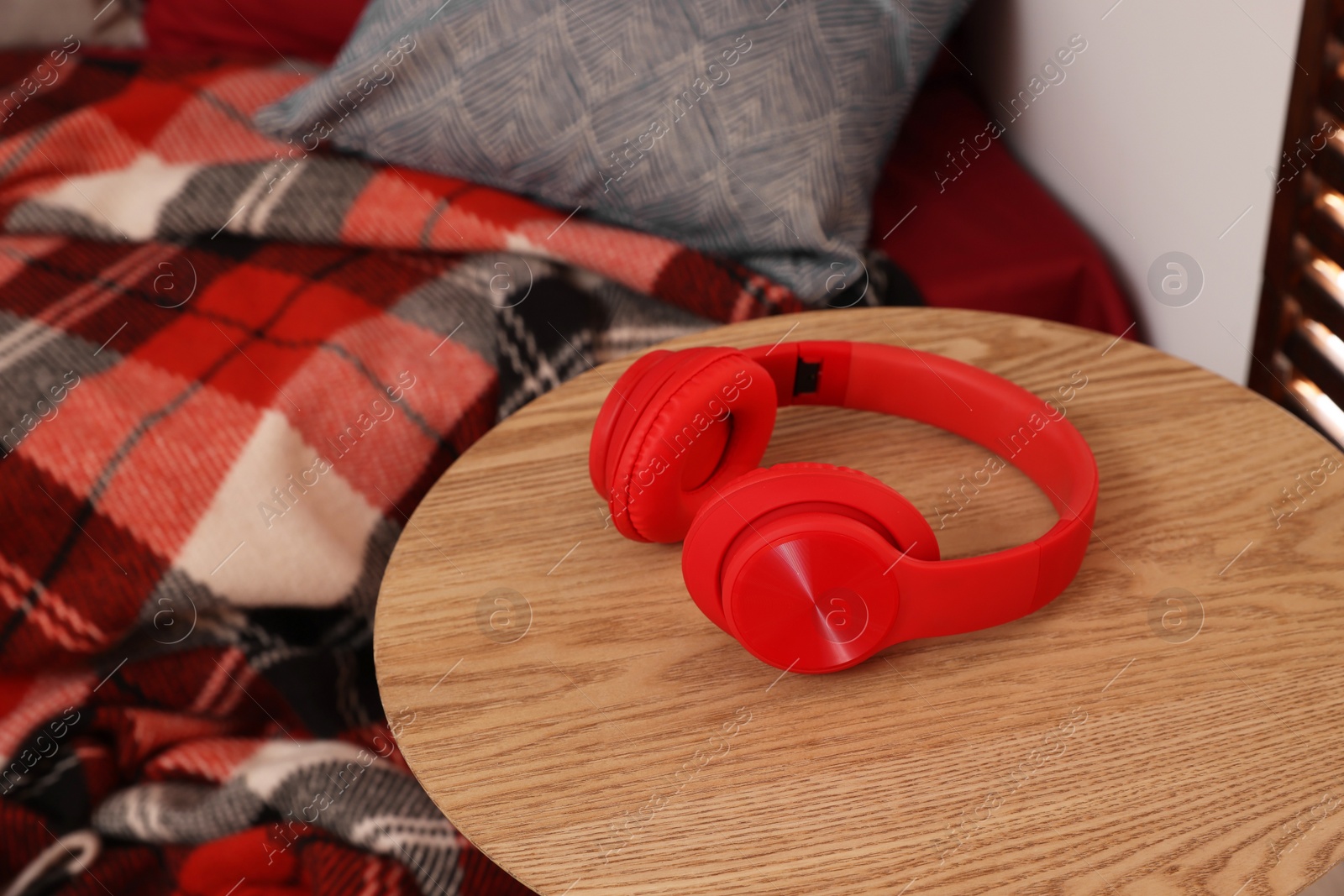 Photo of Red headphones on wooden table in teenager's room