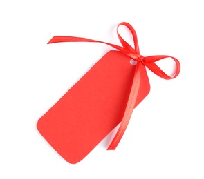 Photo of Blank red gift tag with satin ribbon on white background, top view