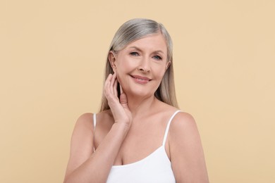 Photo of Portrait of beautiful senior woman on beige background