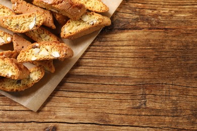 Photo of Traditional Italian almond biscuits (Cantucci) on white wooden table, flat lay. Space for text