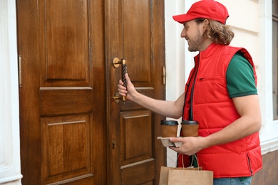 Photo of Male courier with order at entrance. Food delivery service