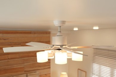 Photo of Modern ceiling fan with lamps indoors. Interior element