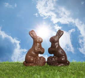 Image of Chocolate bunnies on green grass outdoors. Easter celebration
