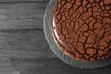 Photo of Delicious chocolate truffle cake on black wooden table, top view. Space for text