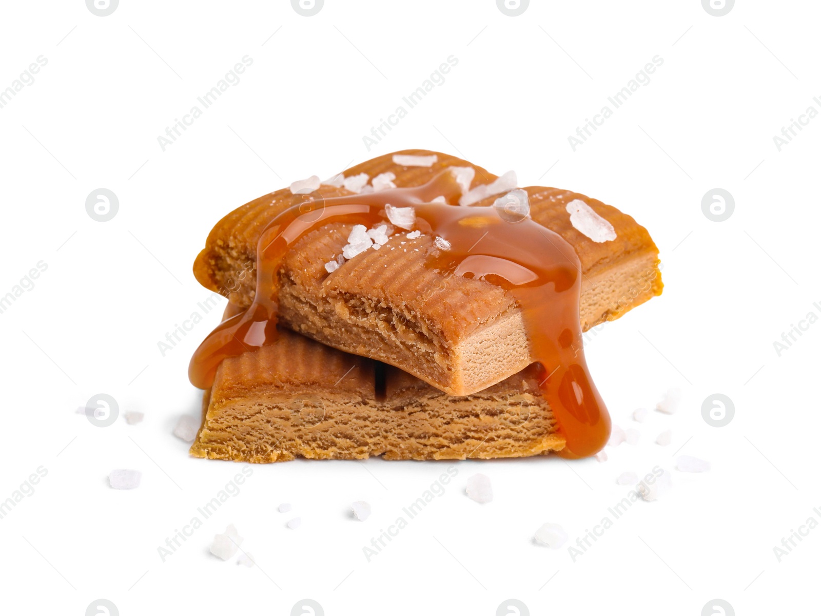 Photo of Yummy caramel candies and sea salt isolated on white