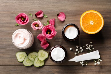 Photo of Flat lay composition with jars and tubeface cream on wooden table