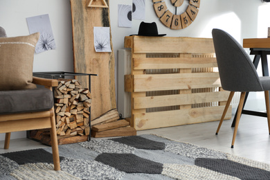 Firewood as decorative element in stylish room interior