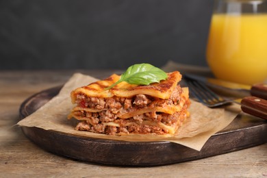 Photo of Tasty cooked lasagna served on wooden table, closeup