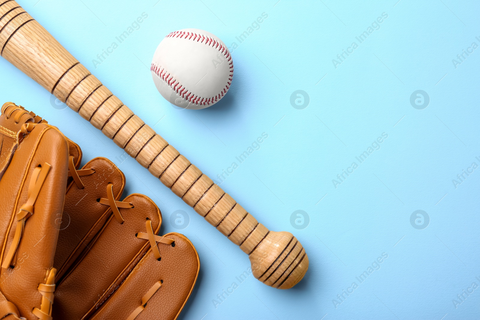 Photo of Baseball glove, bat and ball on pale light blue background, flat lay. Space for text