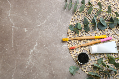 Photo of Flat lay composition with bamboo toothbrushes on grey marble table. Space for text