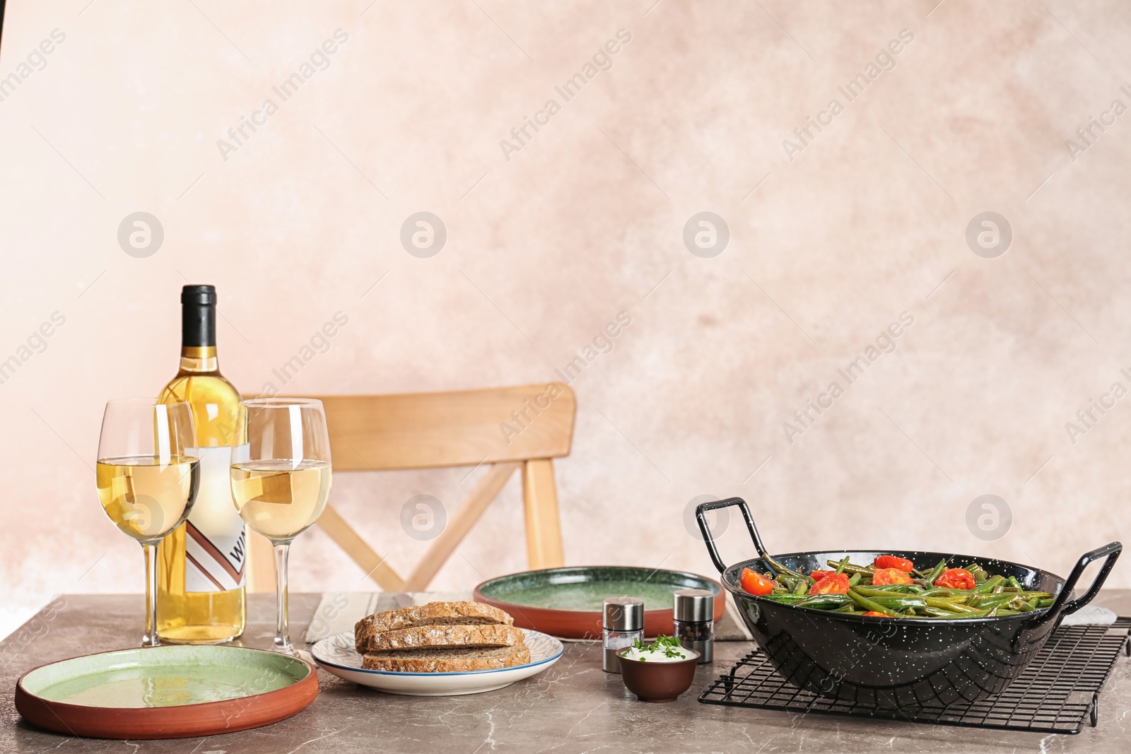 Photo of Tasty green bean dish and wine served for dinner on table