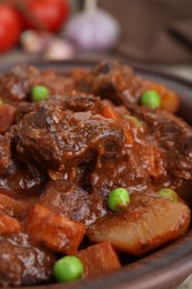Photo of Delicious beef stew with carrots, peas and potatoes, closeup